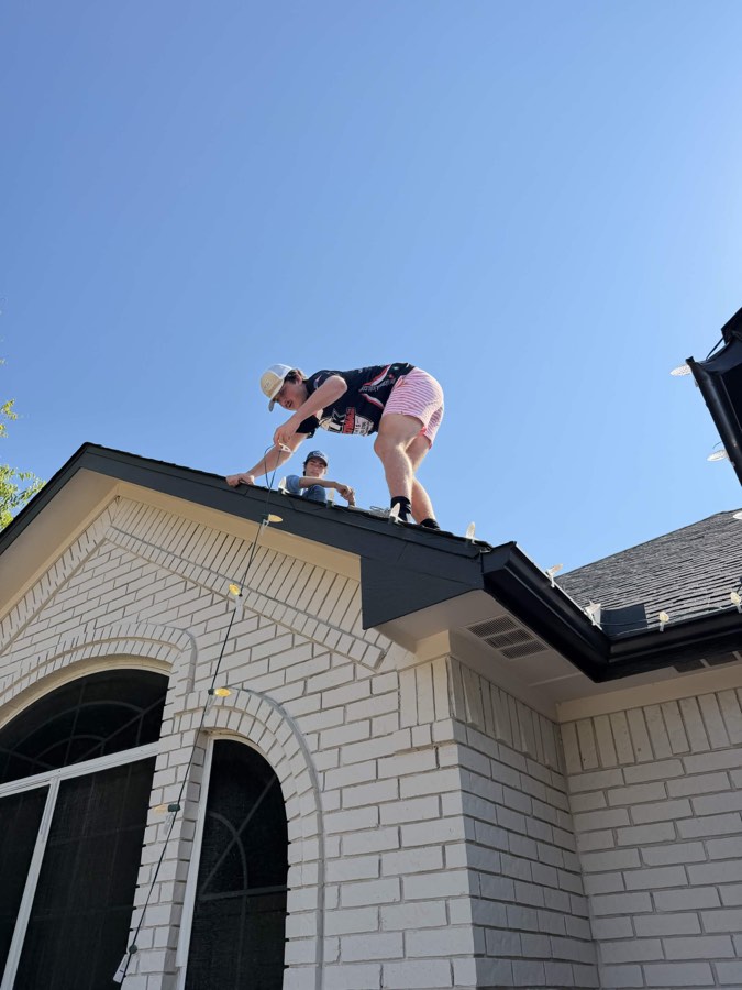 Christmas lights training team on roof